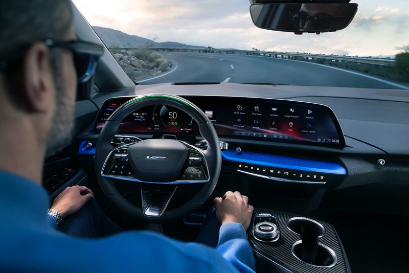 Front View of the 2026 OPTIQ-V Driving Through the Dusk Utilizing its Headlights | Paradise Cadillac in Temecula CA
