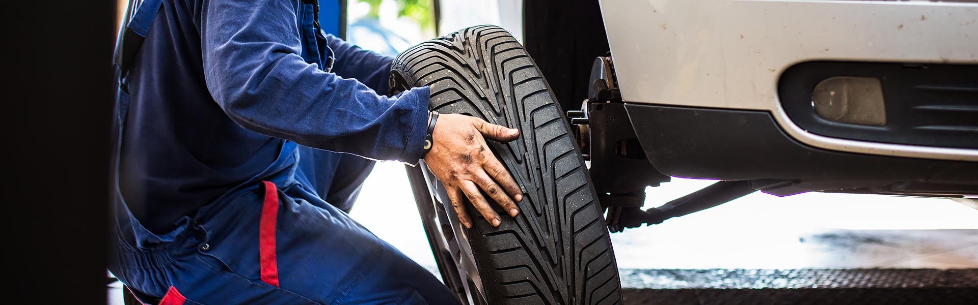 Auto technician changing a car tire in a service shop